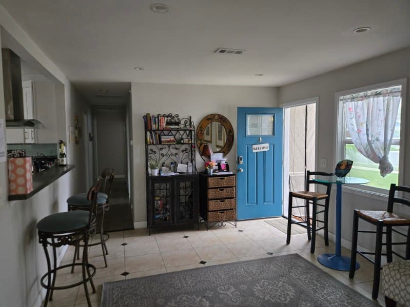 Agape House 3 entryway — warm welcome area with seating and kitchen bar