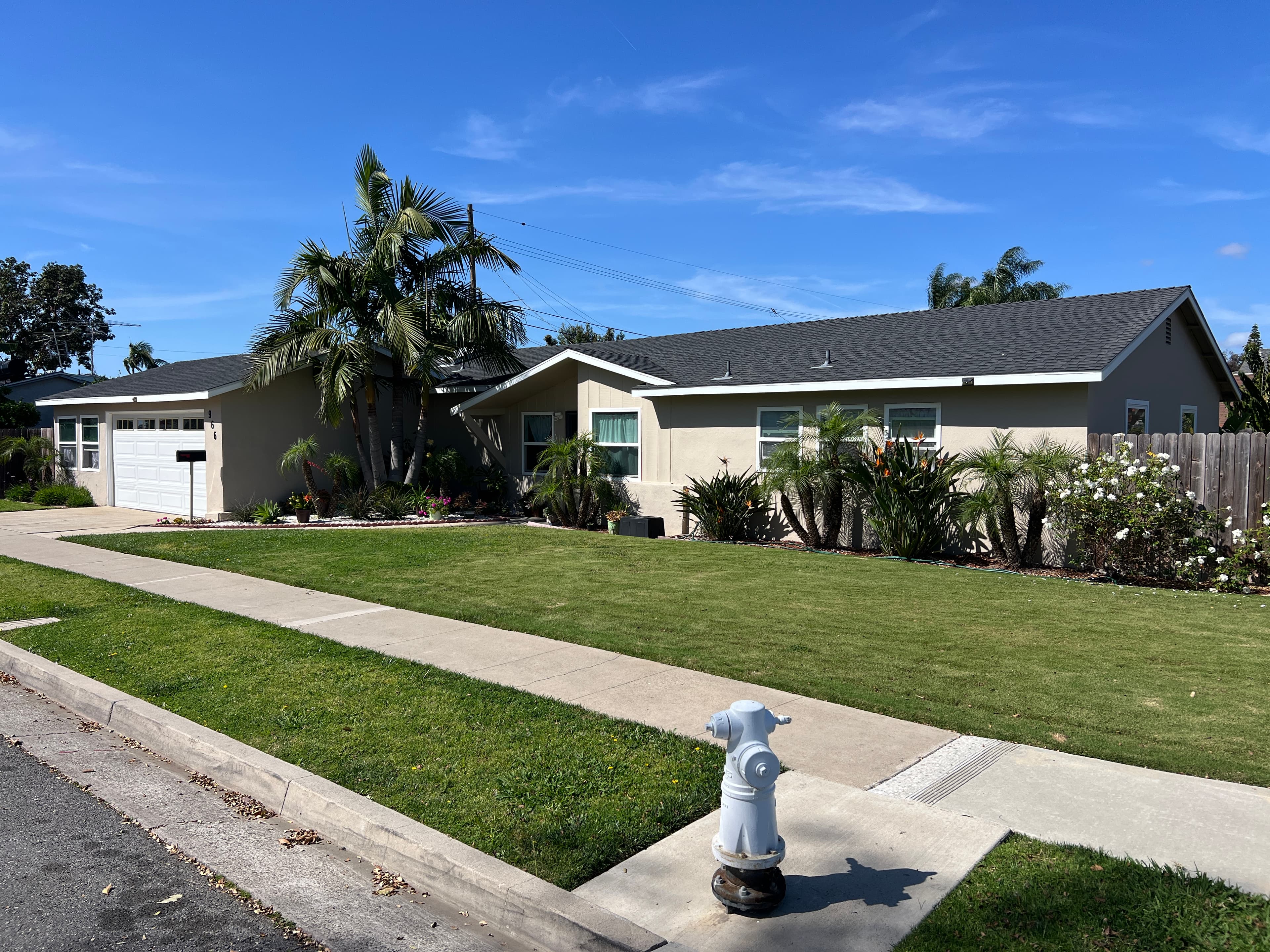 Agape House 3 front view — spacious lawn, palm trees, and landscaped yard