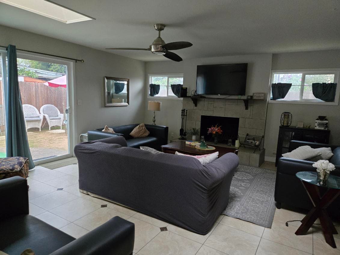 Agape House 3 den — comfortable couches, fireplace, TV, and backyard access