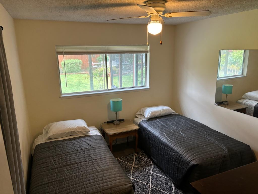 Shared bedroom with twin beds and ceiling fan
